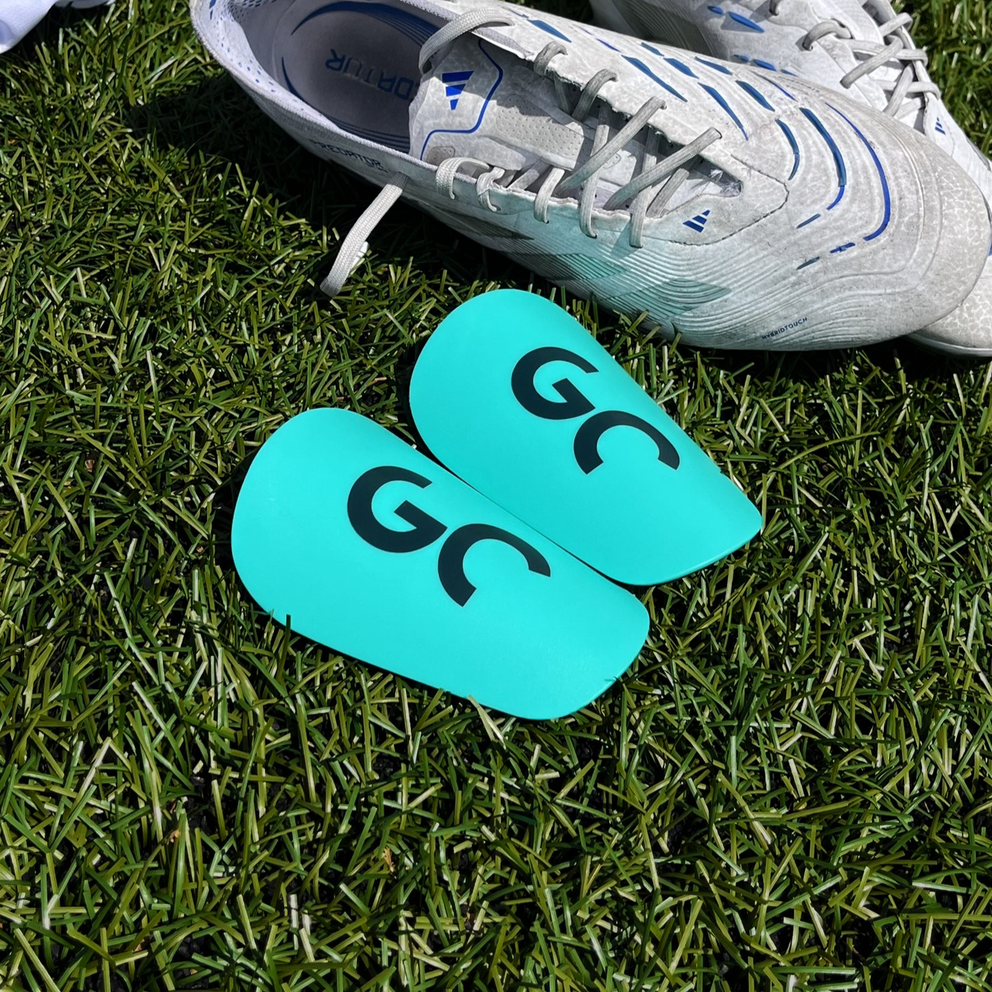Mini protège-tibias discrets pour footballeurs confort et compacts, posées sur terrain de football| Game Changer